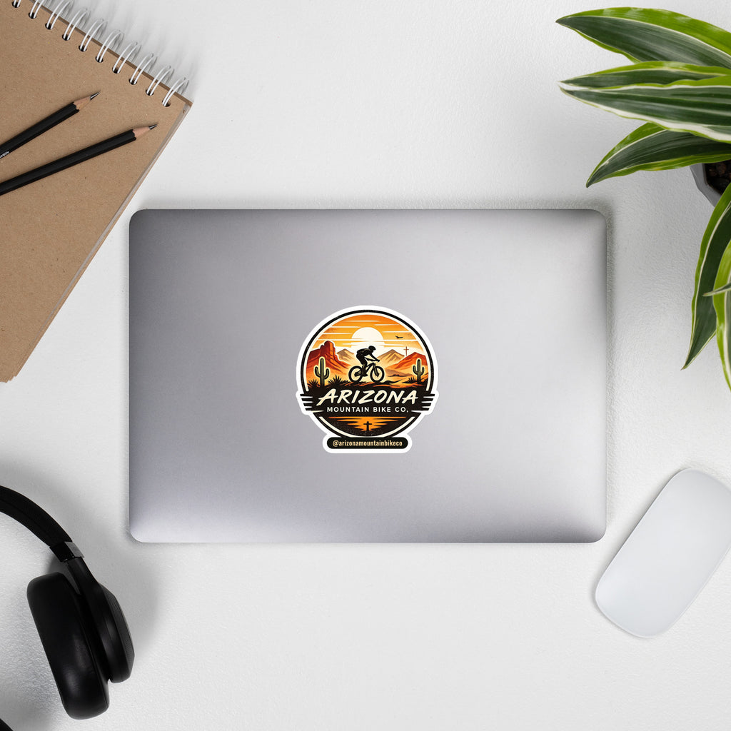 AZMTBCo Logo Sticker on a laptop, round Arizona Mountain Bike Co. sunset badge kiss-cut sticker